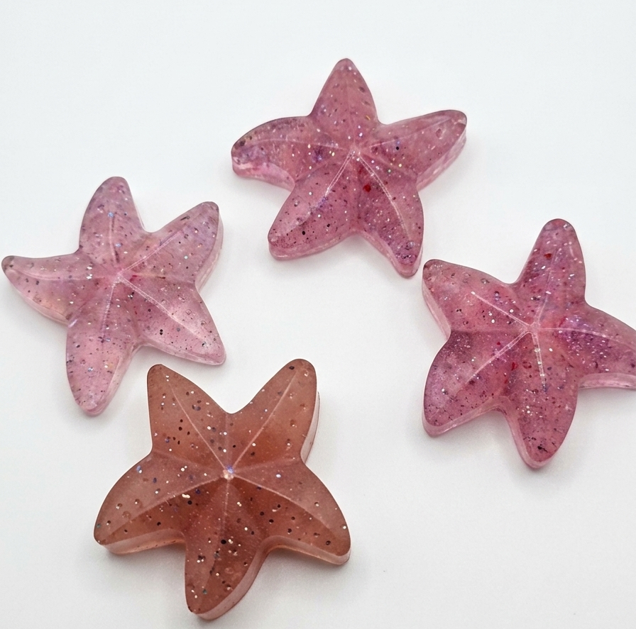 Four pink star-shaped objects on a white background