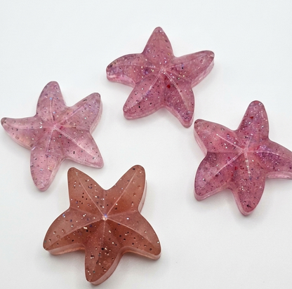 Four pink star-shaped objects on a white background