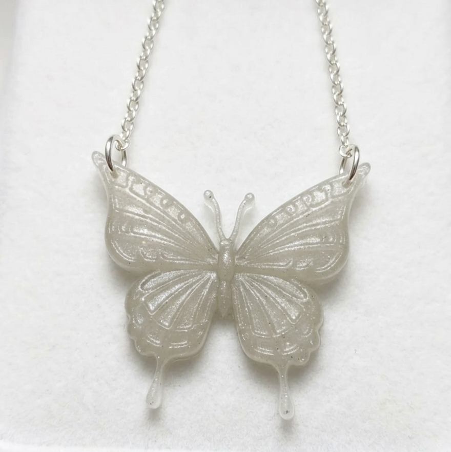 Silver butterfly necklace on a white background